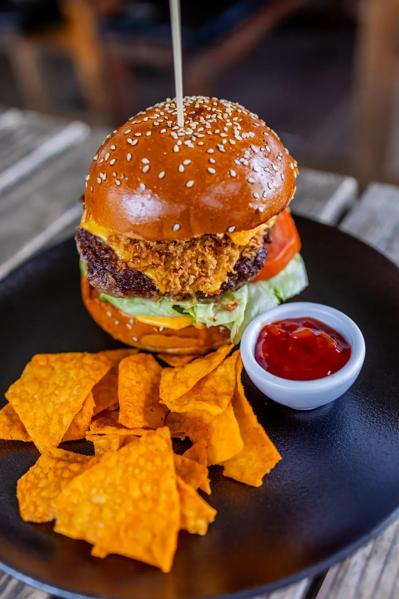 Burger s hrustljavo panirano piščančjo zrezko in tortilja čipsom