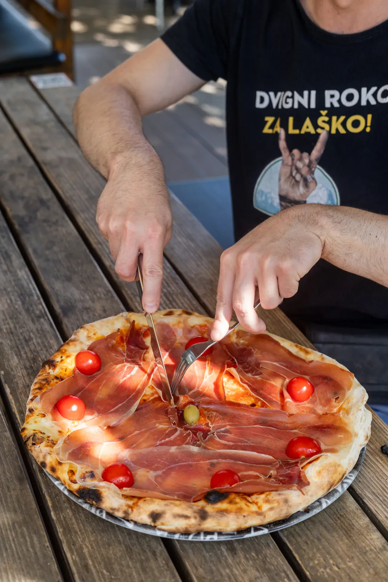 Rezanje pice s pršutom za mizo