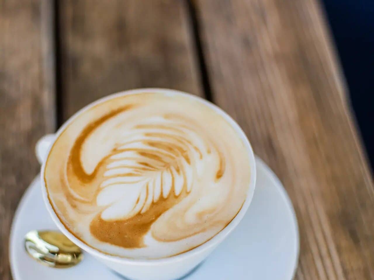 Cappuccino z latte artom na leseni mizi